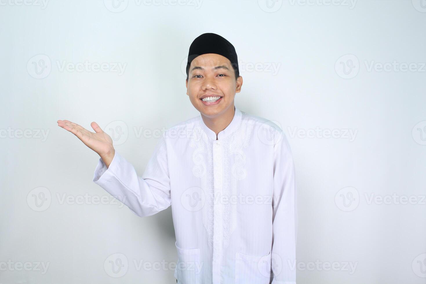 attractive muslim asian man presenting hand to the right side with smiling face isolated on white background, looking at camera photo