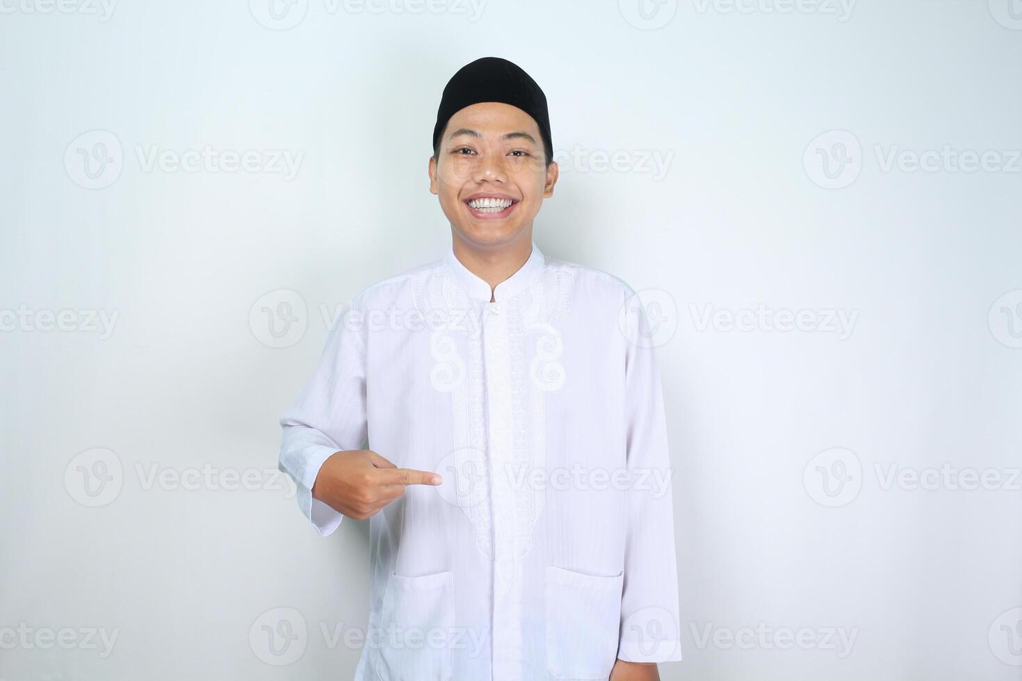 happy muslim asian man isolated on white background pointing finger to the center photo