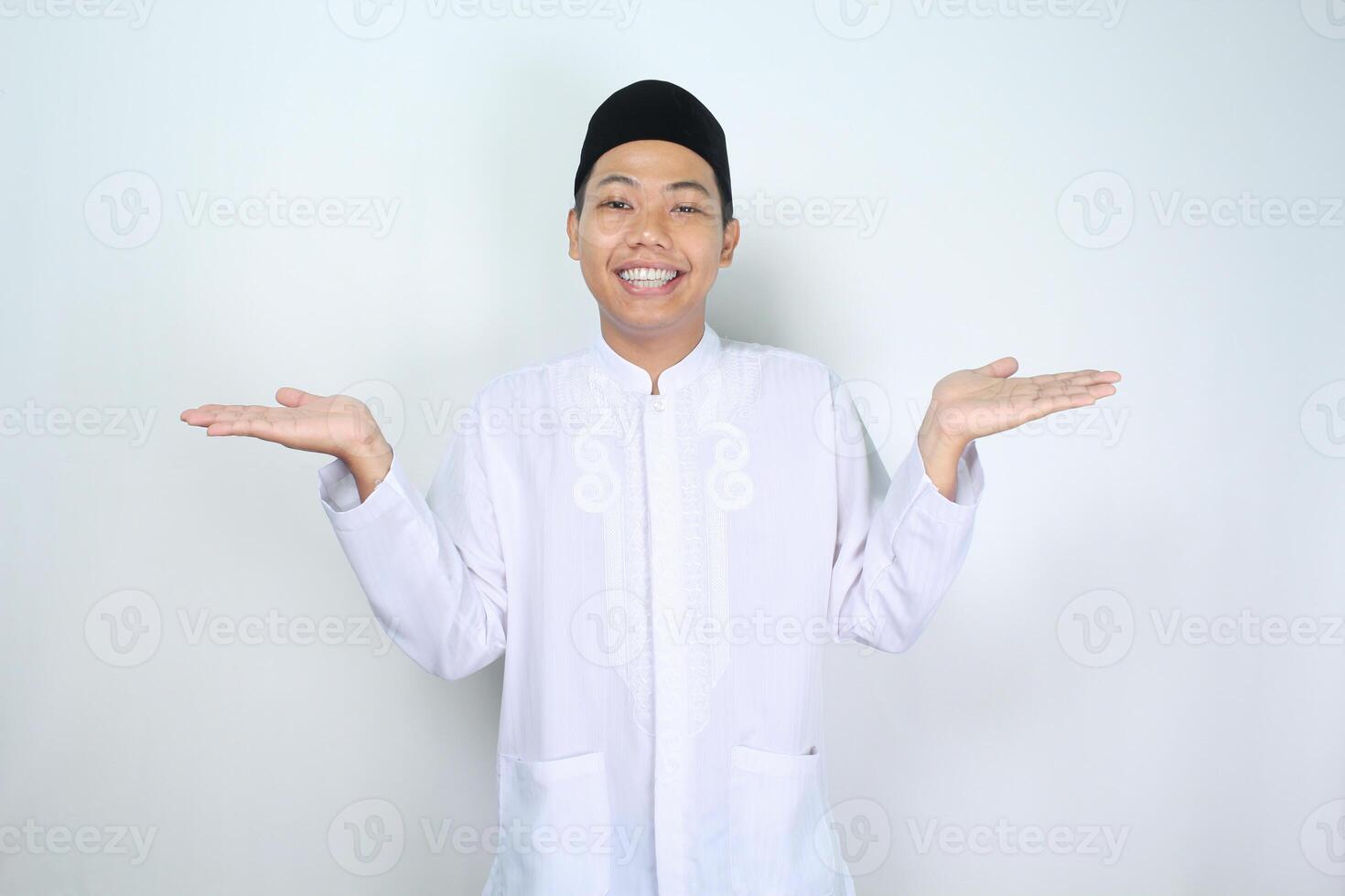 attractive muslim asian man presenting hand two sideway with smiling face isolated on white background, looking at camera photo