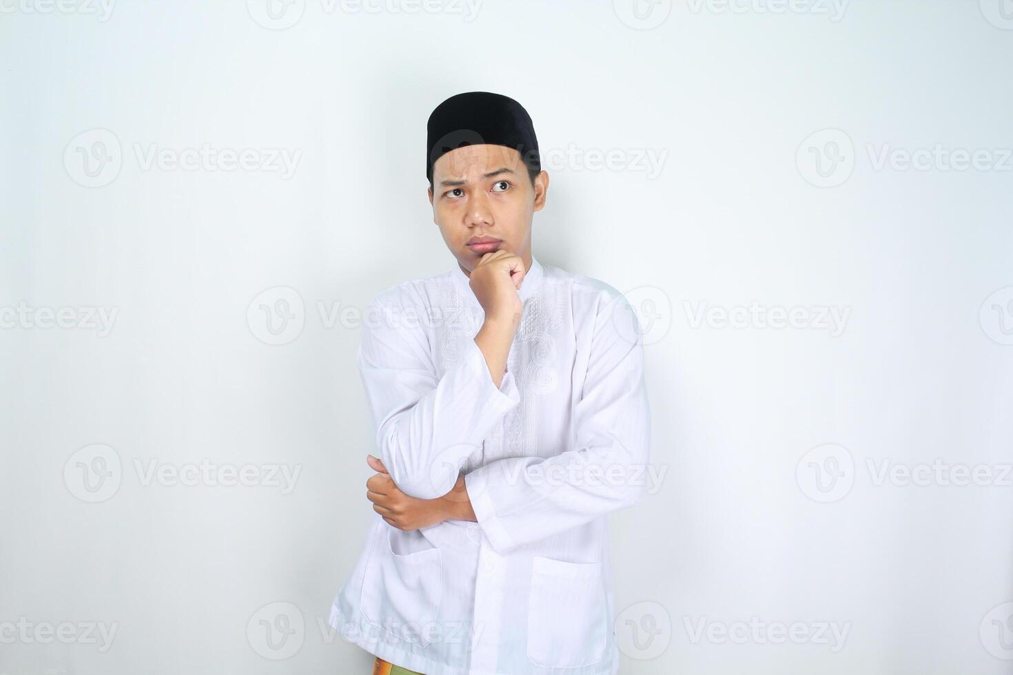 pensive muslim man asian looking up corner with hand on chin to think about something isolated on white background photo