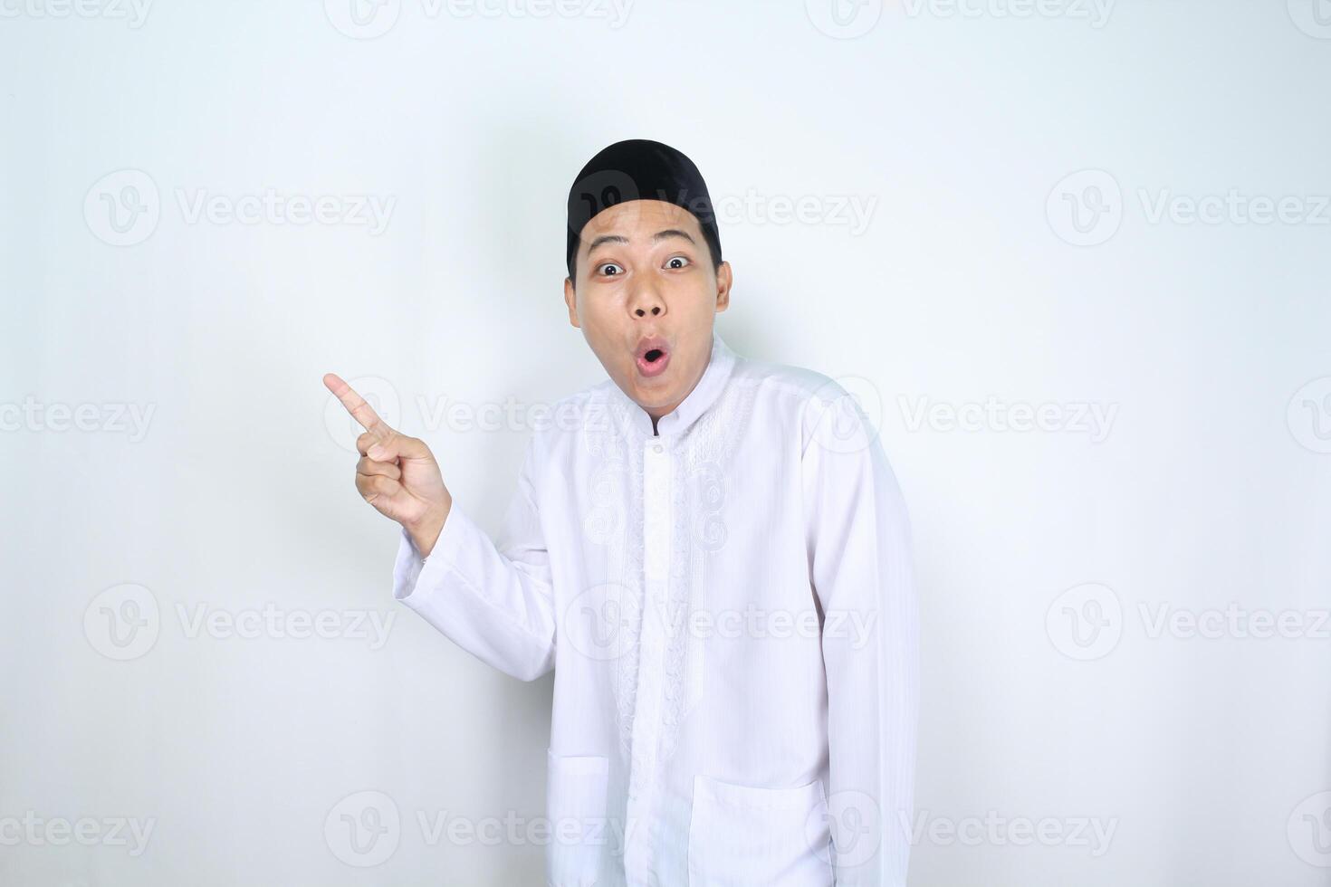 funny muslim man asian pointing to beside with shocked expression isolated on white background photo