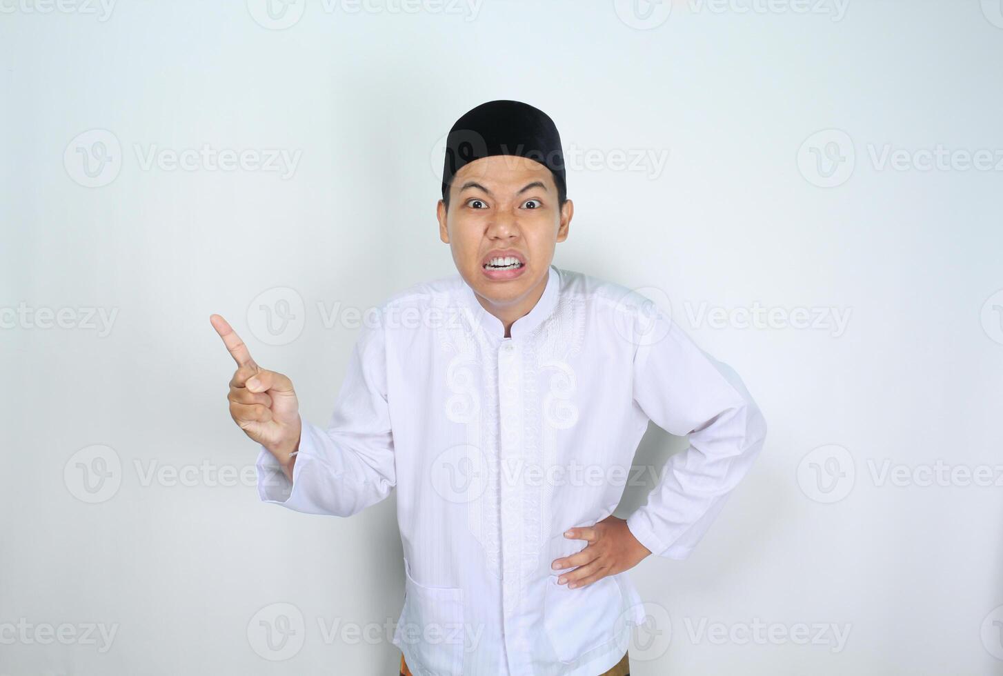 angry muslim asian man pointing to side isolated on white background photo