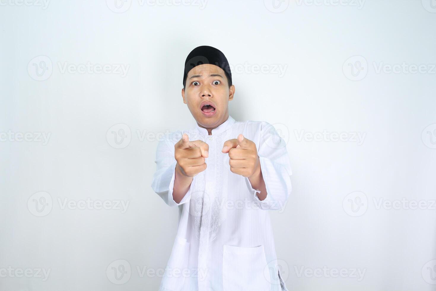 asiático hombre musulmán señalando adelante con conmocionado expresión aislado en blanco antecedentes foto
