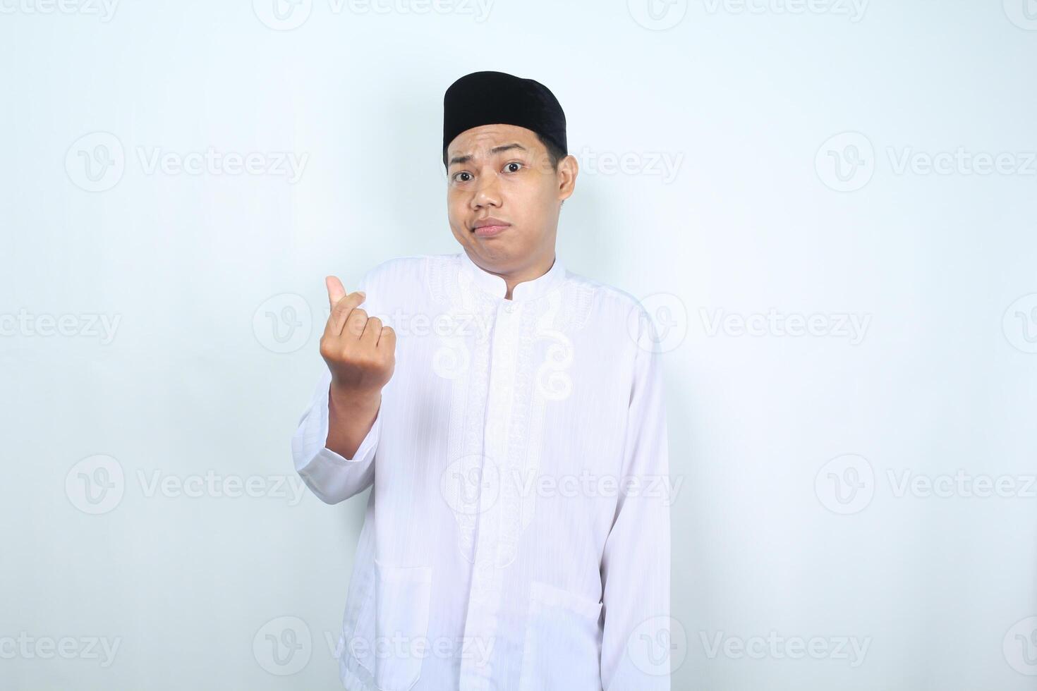 infeliz asiático musulmán hombre mirando a cámara con coreano amor firmar aislado en blanco antecedentes foto