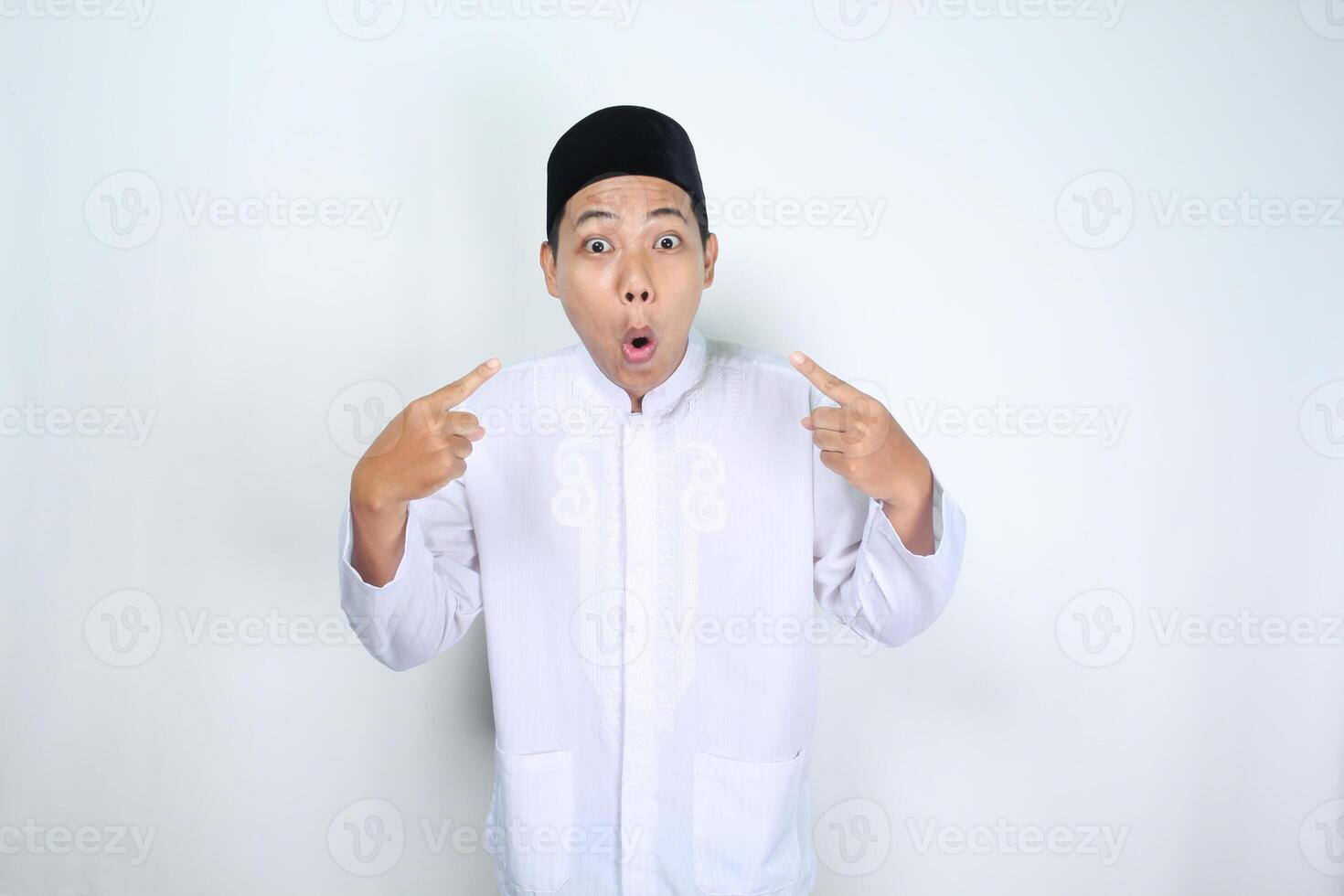 shocked asian man muslim pointing to him self isolated on white background photo