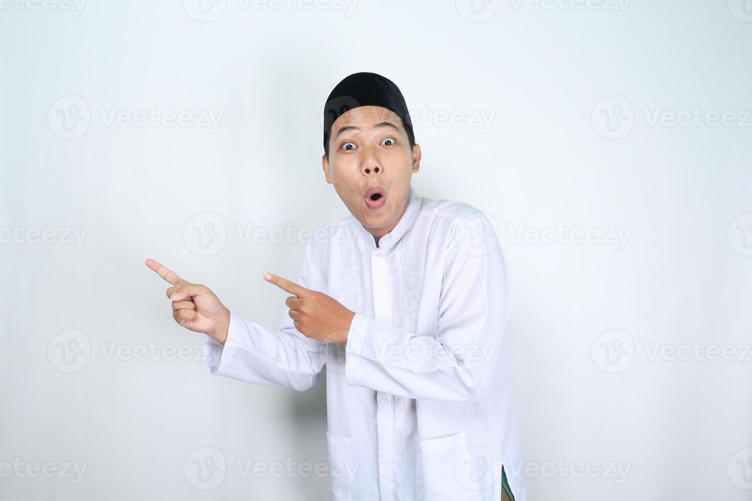 funny muslim man asian pointing to beside with shocked expression isolated on white background photo