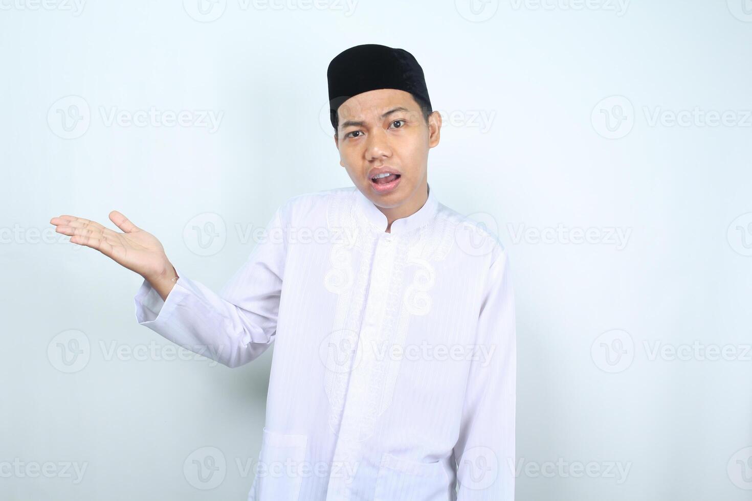 confused asian muslim man presenting to empty side isolated on white backround photo