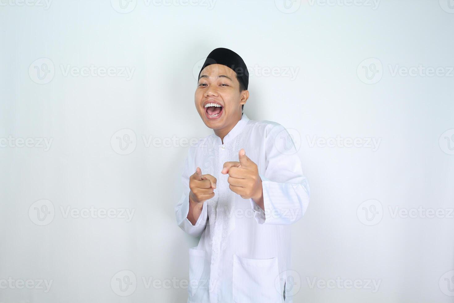 attractive muslim asian man pointing forward and shouting with mouth open isolated on white background photo