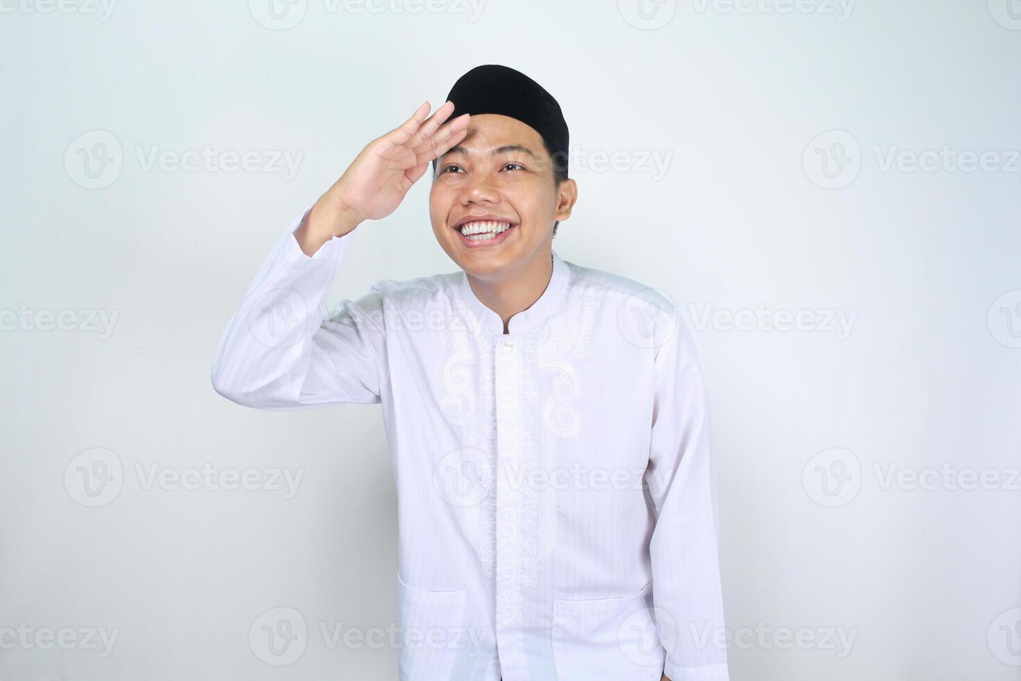 sonriente asiático hombre musulmán mirando lejos lejos con emoción aislado en blanco antecedentes foto