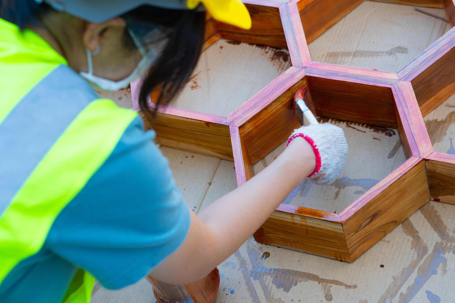 Asian female worker painting wooden furniture at a job site. photo