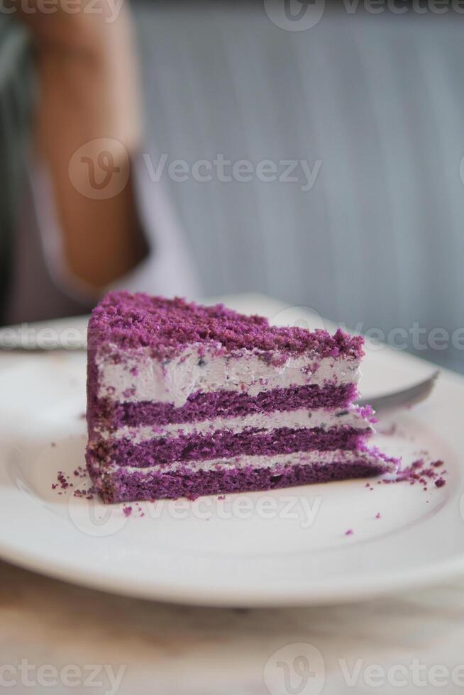 corte un pedazo de púrpura terciopelo pastel con crema foto