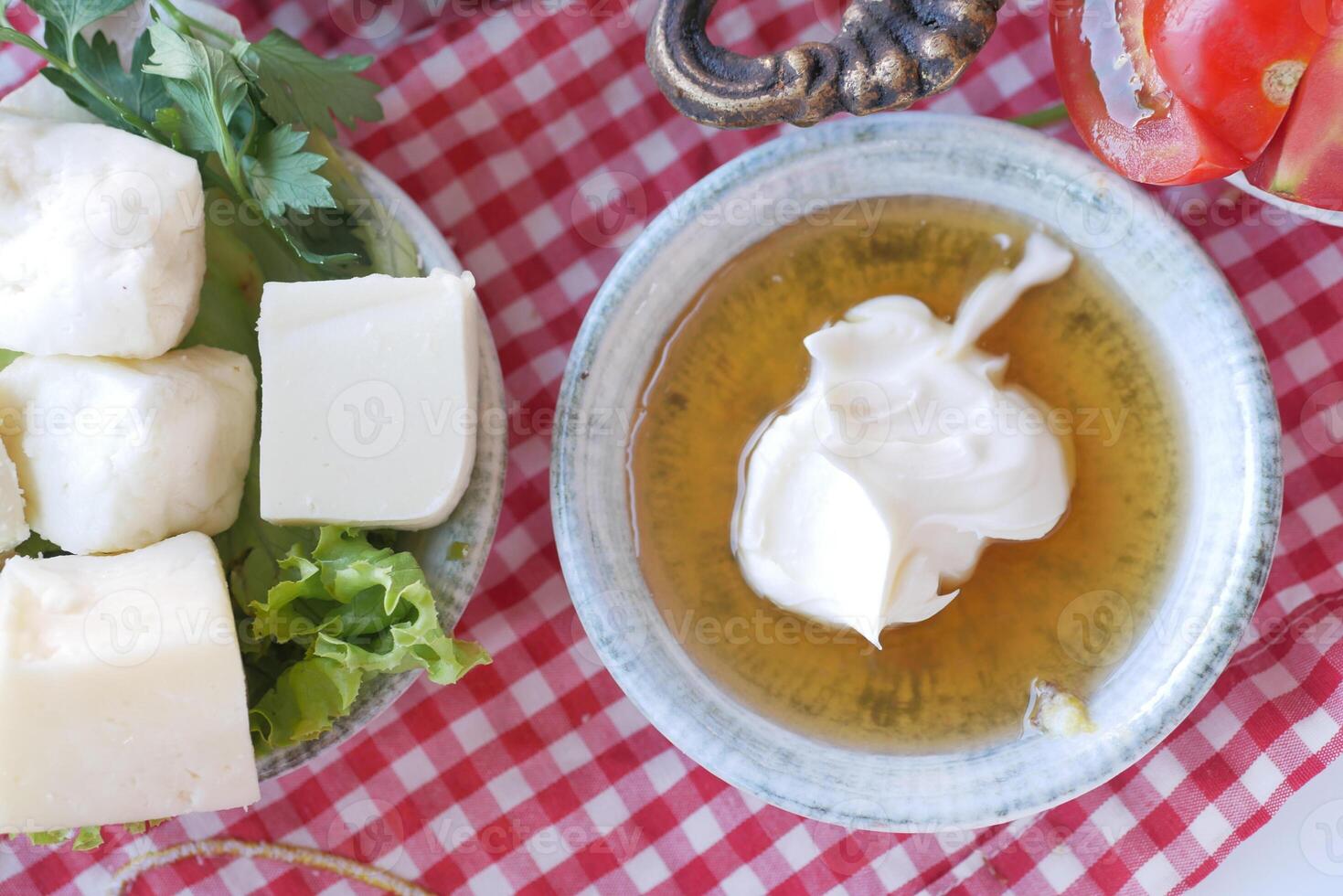 butter cream and honey in a bowl on table . photo