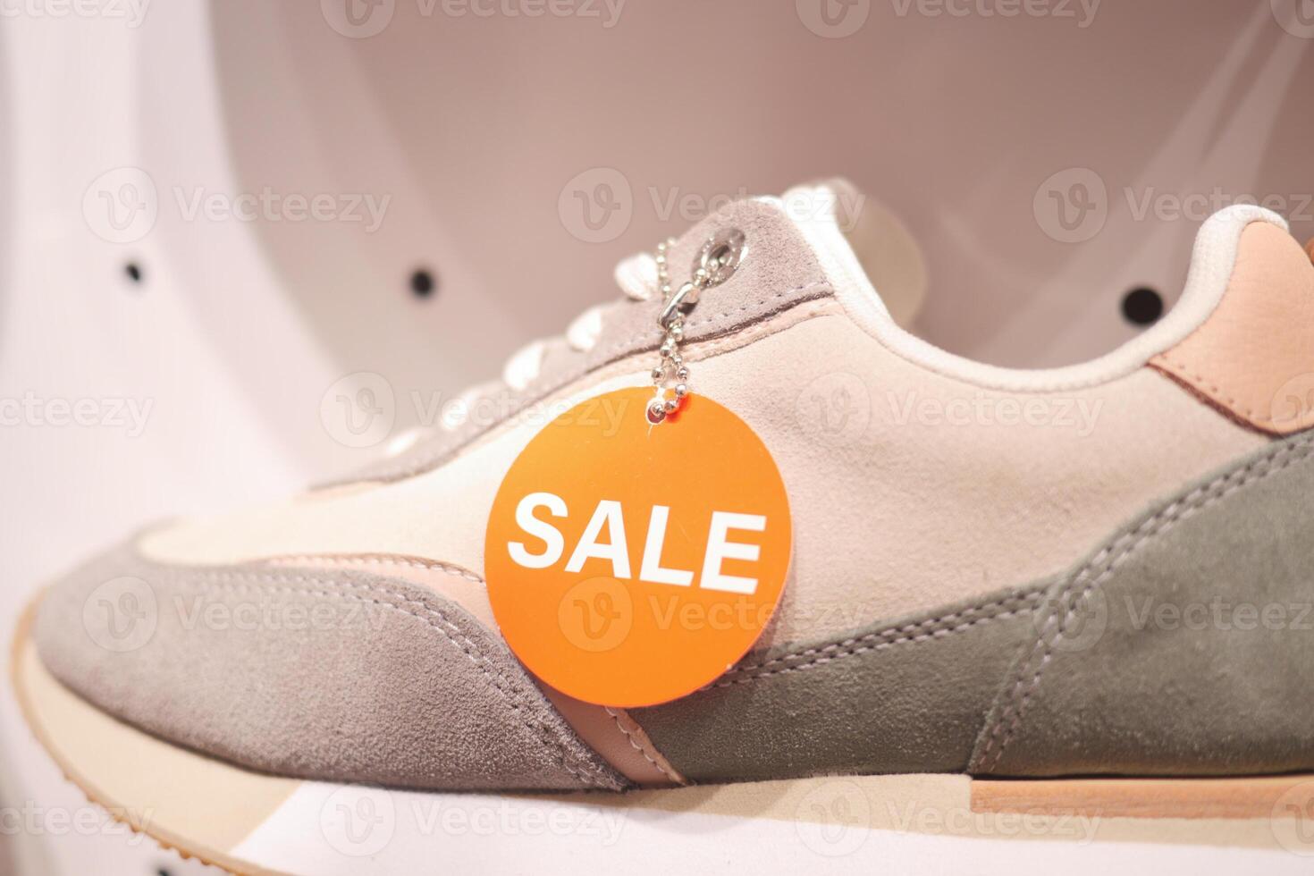 sales sticker on the Pair of new stylish white sneakers photo