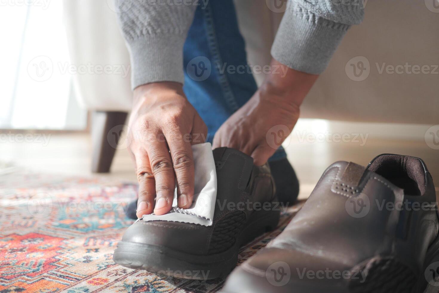 Men wipes his leather shoes with a wet cloth photo