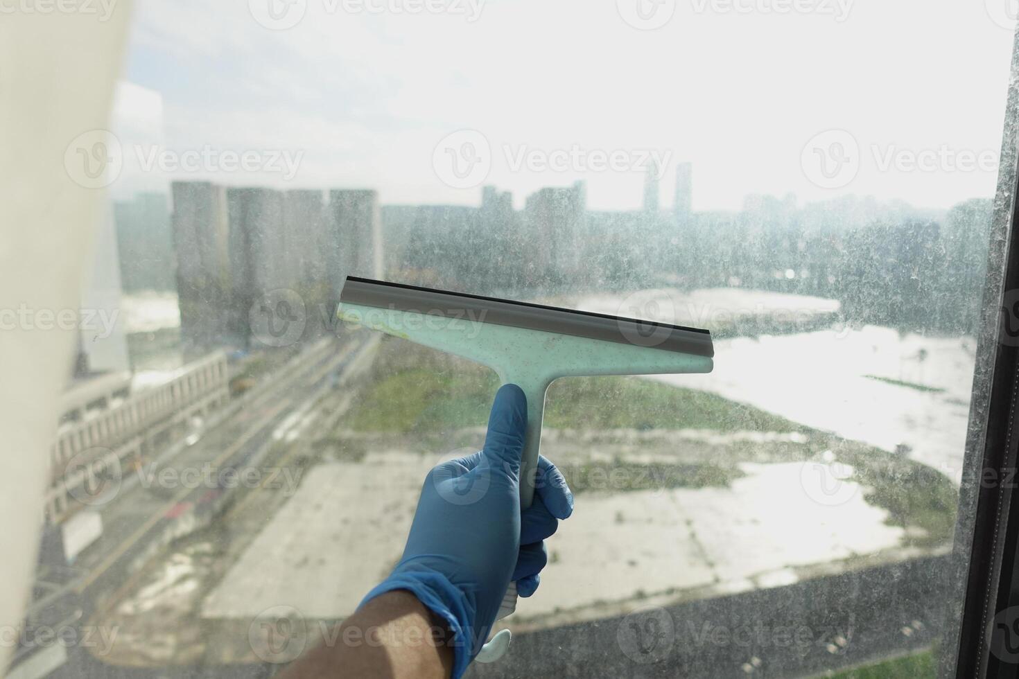 Rubber squeegee cleans a soaped window. photo