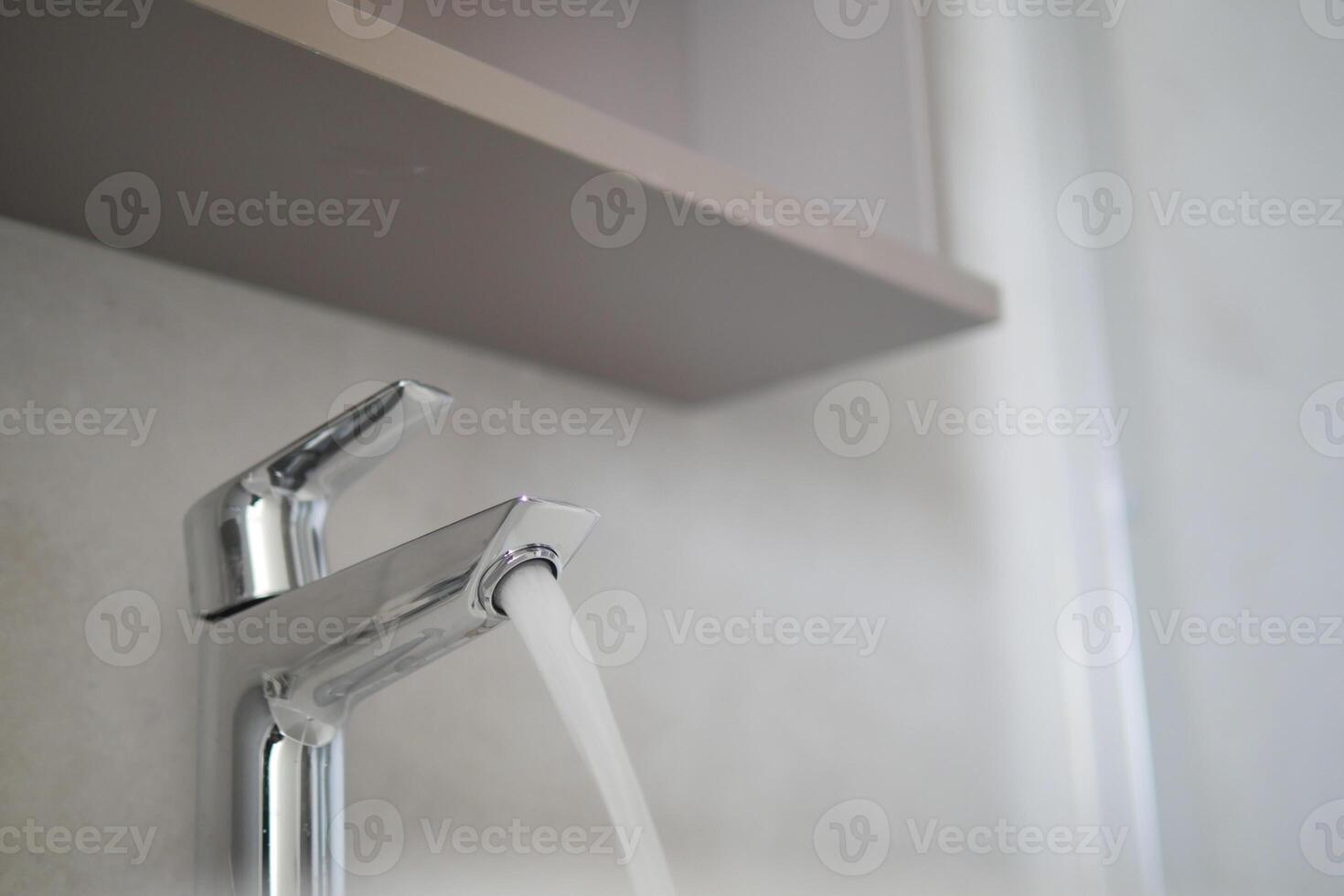 Water dripping from faucet tap at kitchen. Closeup photo