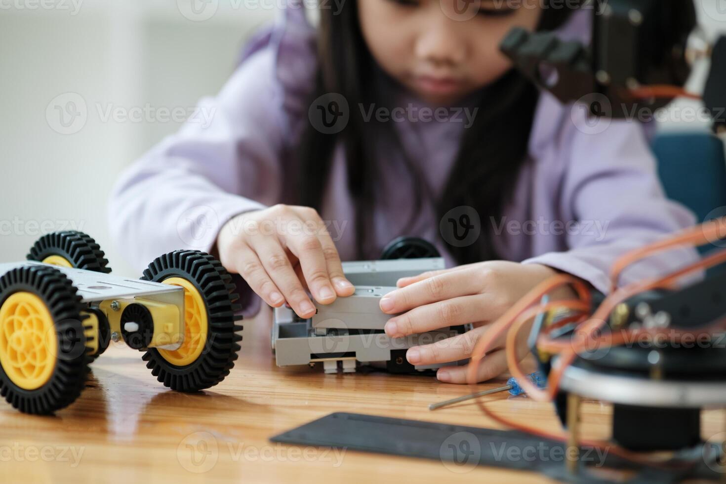 STEM education concept. Asian young girl learning robot design. photo