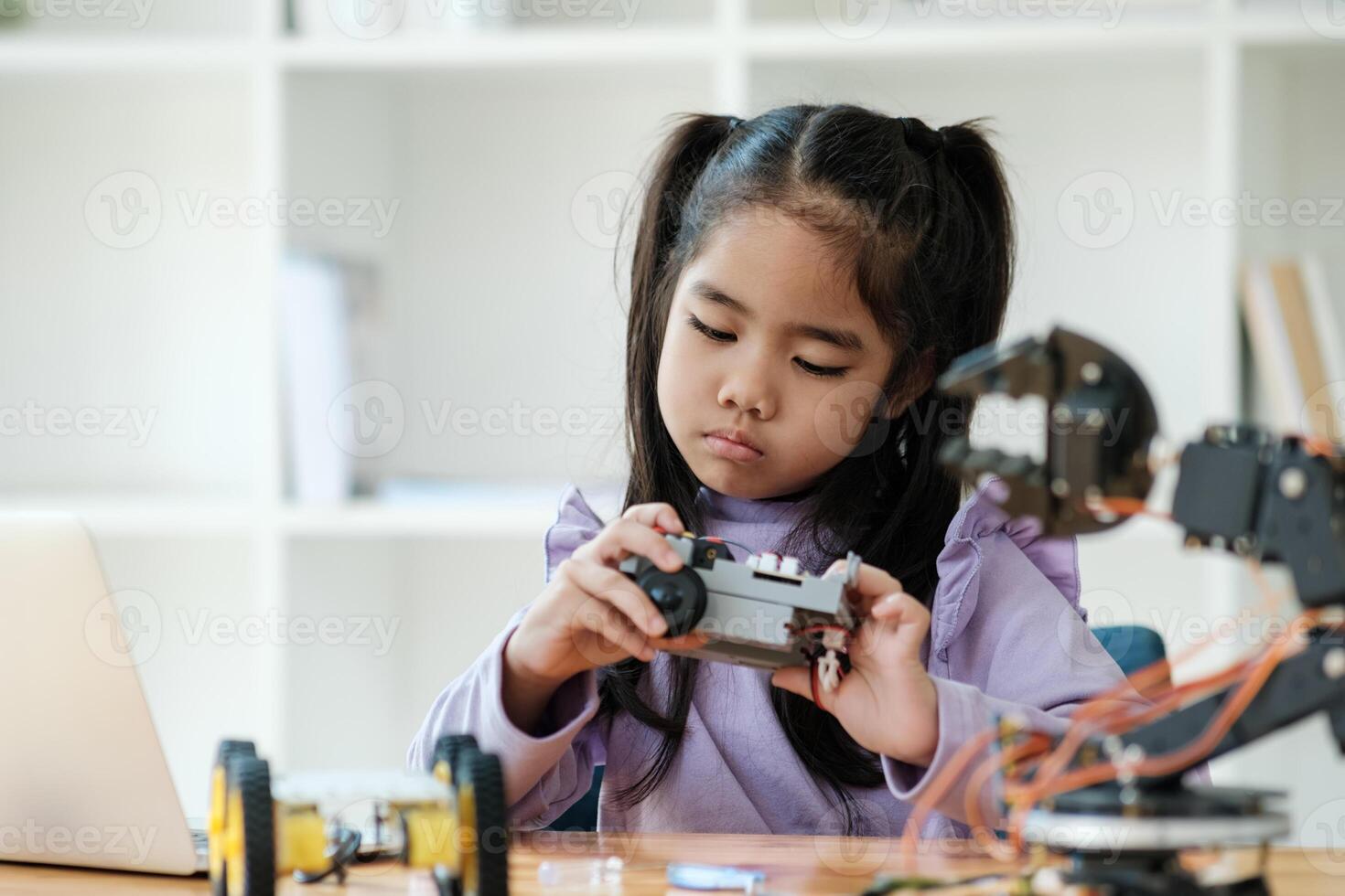 STEM education concept. Asian young girl learning robot design. photo