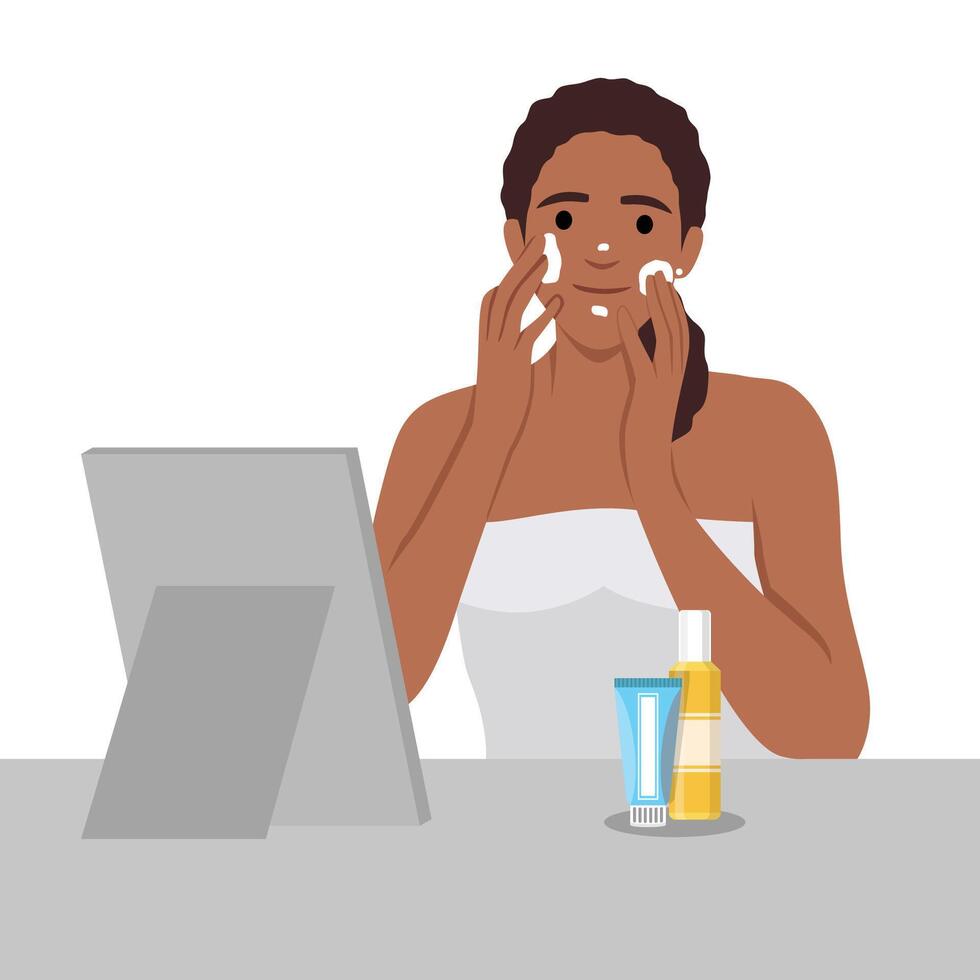 Beautiful woman cares for her facial skin. Girl wearing a towel applies cream to her face. Self-care concept. Morning routine. Lady with a jar of cream in hands vector