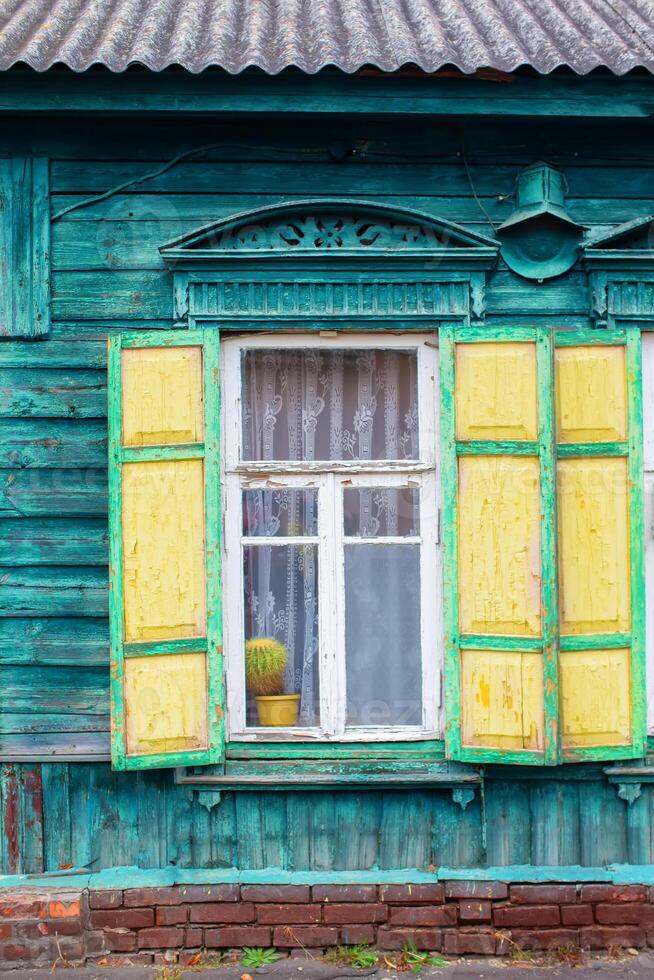 antecedentes de un antiguo ventana con de madera persianas pared de un de madera casa con un ventana. foto