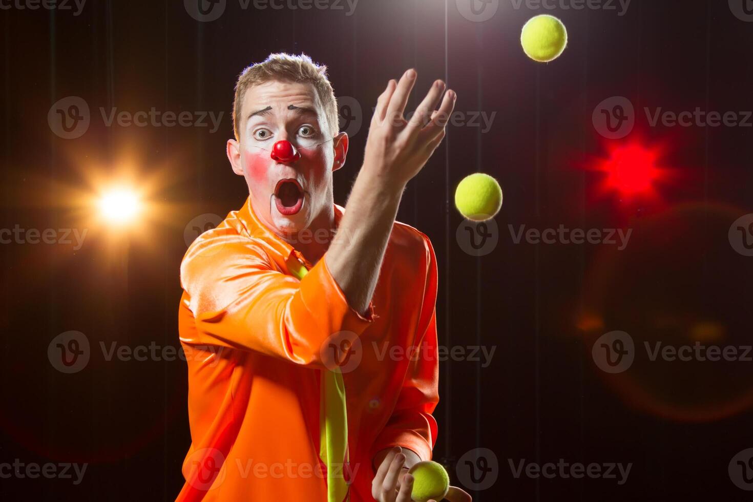 Circus clown performs number. Clown man juggles photo