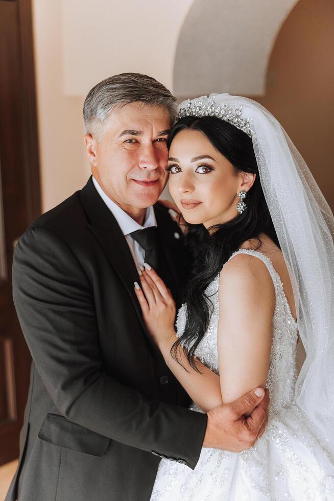 A beautiful bride with her father on her wedding day. The best moments of the wedding day. Daughter and father. photo