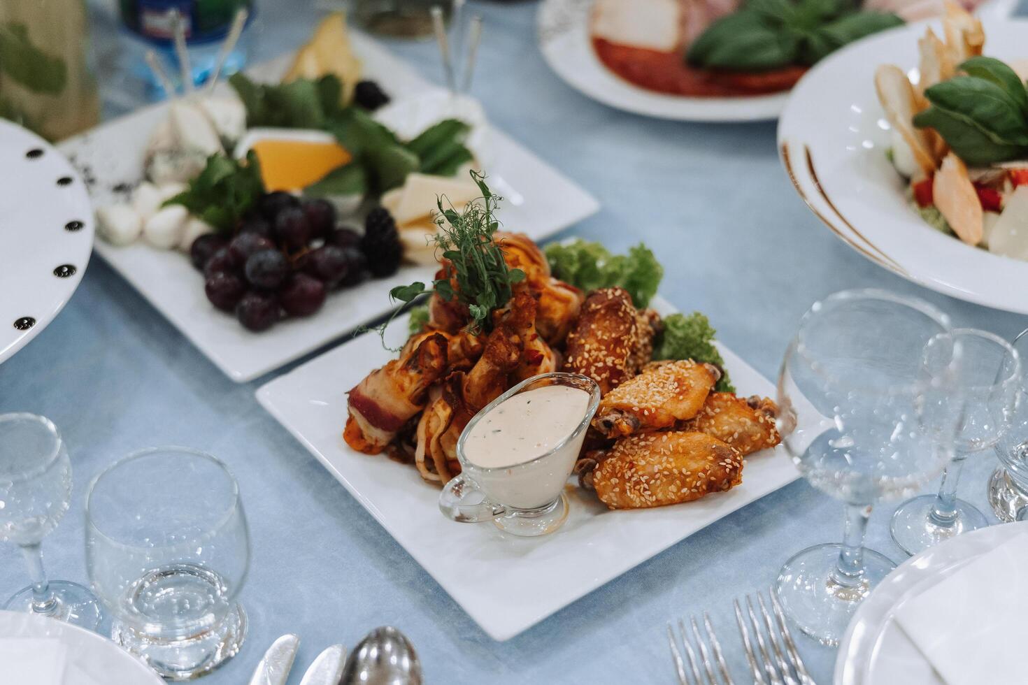 A view of wedding tables, attention to serving, with flower arrangements, expensive cutlery, plates with white napkins. photo