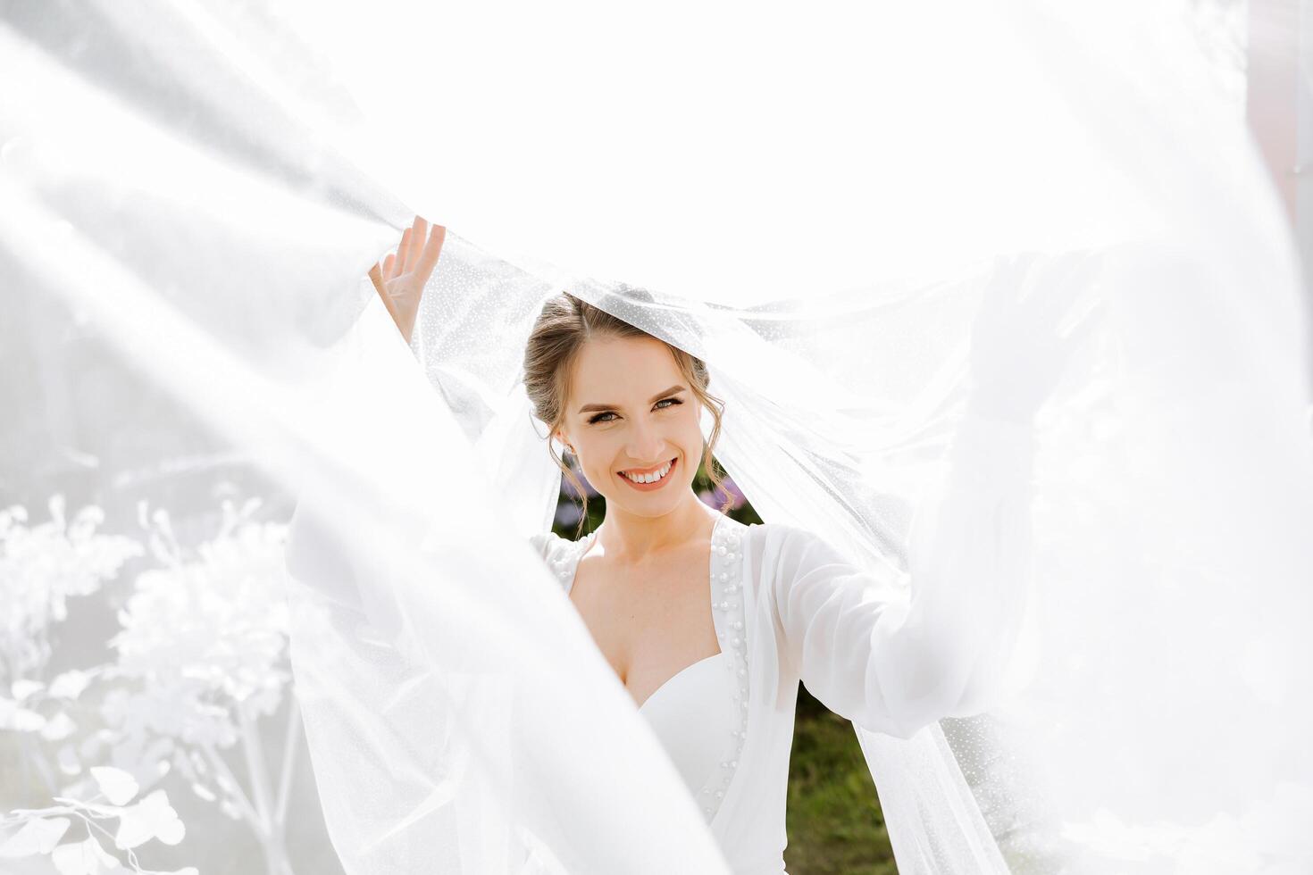 Beautiful bride in a dressing gown in the morning before the wedding ceremony. Incredible hairstyle of the bride. Natural and modern makeup. Portrait of a young bride in a dressing gown. photo