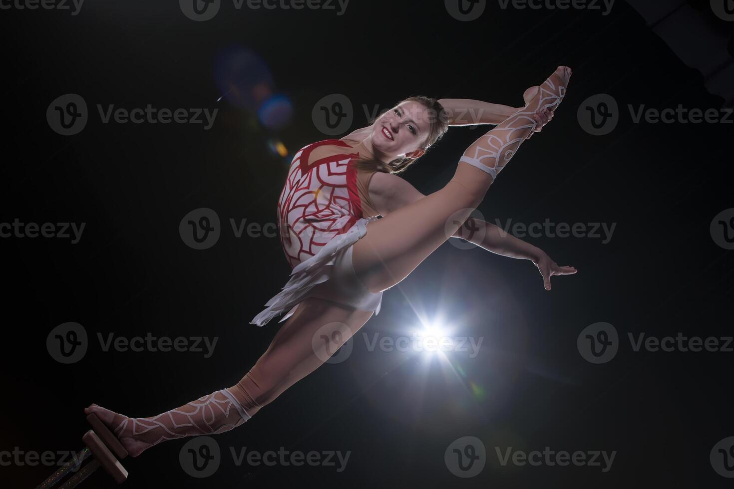 Circus actress performs the number in a beautiful smoke. Manual equilibrium on canes. Flexible girl body.Performance of an air gymnast in a circus photo