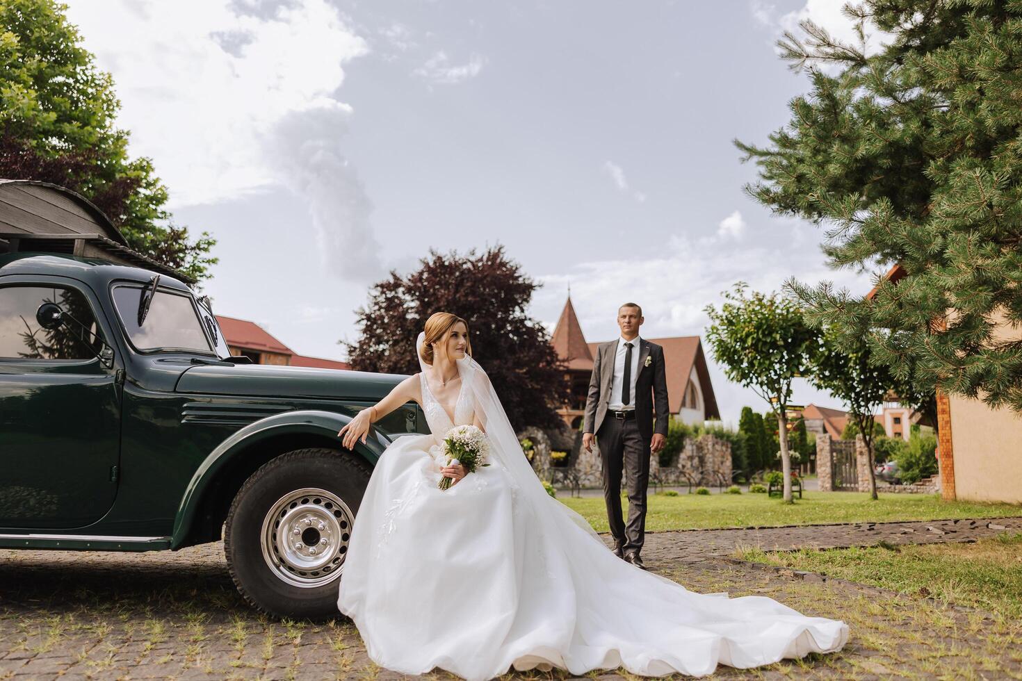 The bride is dressed in an elegant lush white wedding dress with a long veil and is ready for her groom. The first meeting of the bride and groom photo