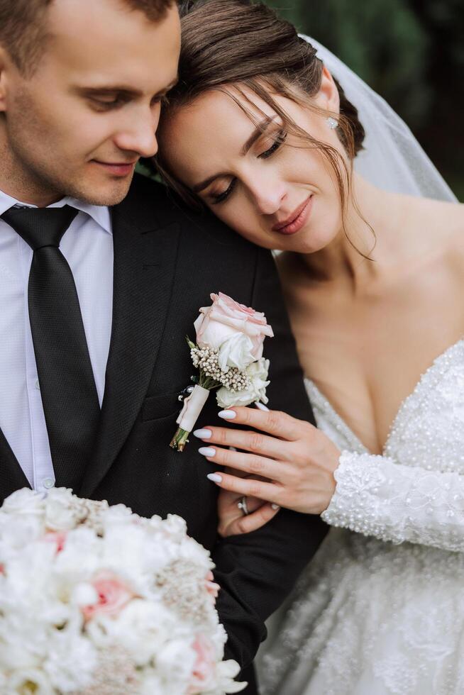 The bride is dressed in an elegant lush white wedding dress with a long veil and is ready for her groom. The first meeting of the bride and groom photo