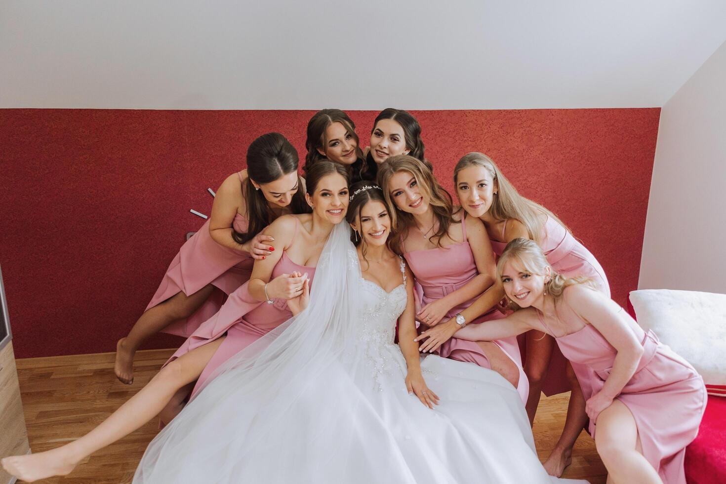 un hermosa novia y su damas de honor son teniendo divertido en el Mañana. Boda celebracion. contento muchachas a su mejor amigos boda. un hermosa y elegante novia con su damas de honor foto