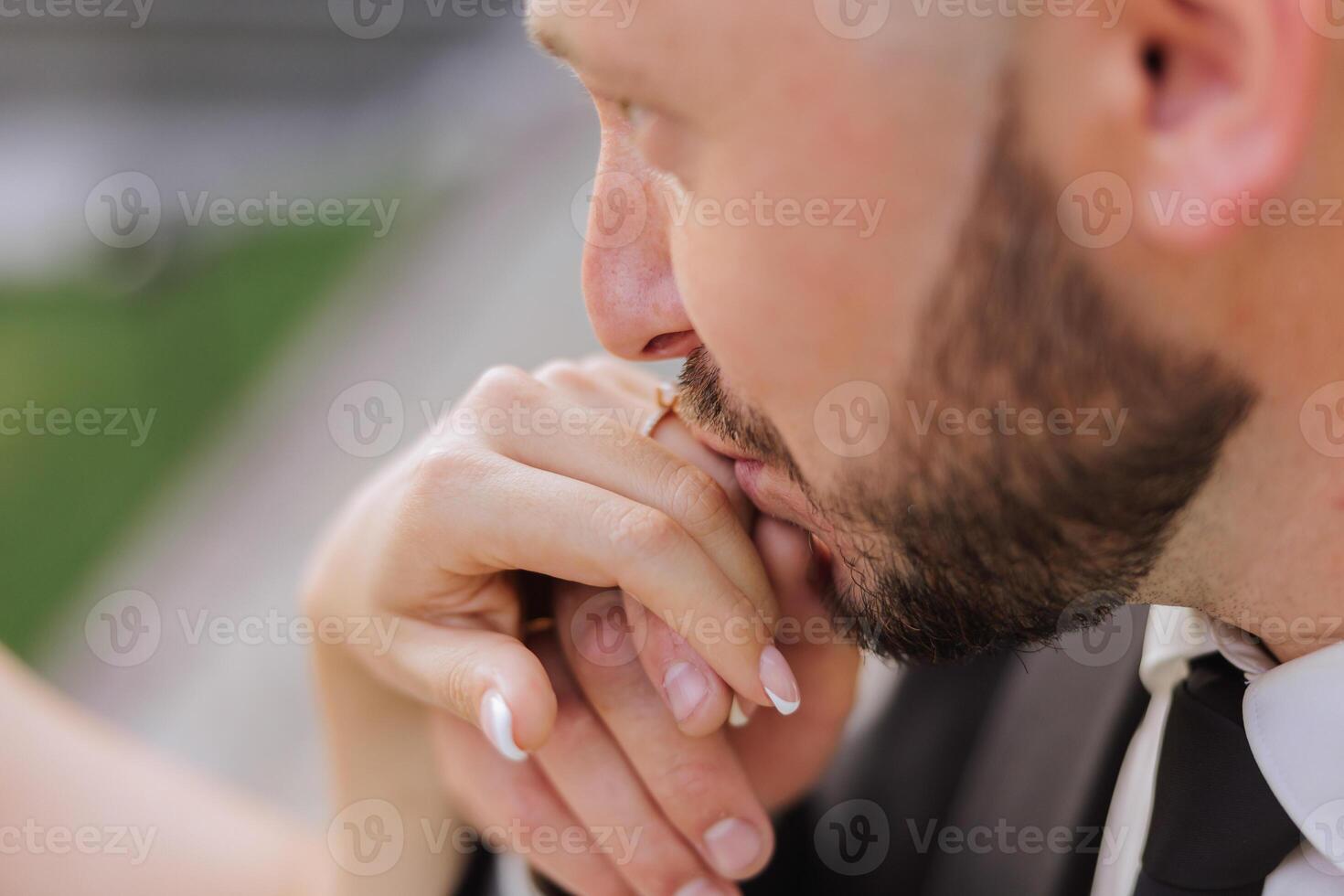 She told him yes. Close-up of a young man kissing his wife's hand with gold ring while making a marriage proposal. Engagement of a young couple in love. The concept of love and togetherness photo