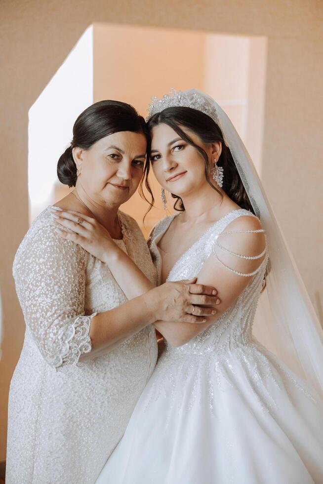 un hermosa y contento madre y su hija, el novia, son en pie siguiente a cada otro. el mejor día para padres. oferta momentos a el boda. foto