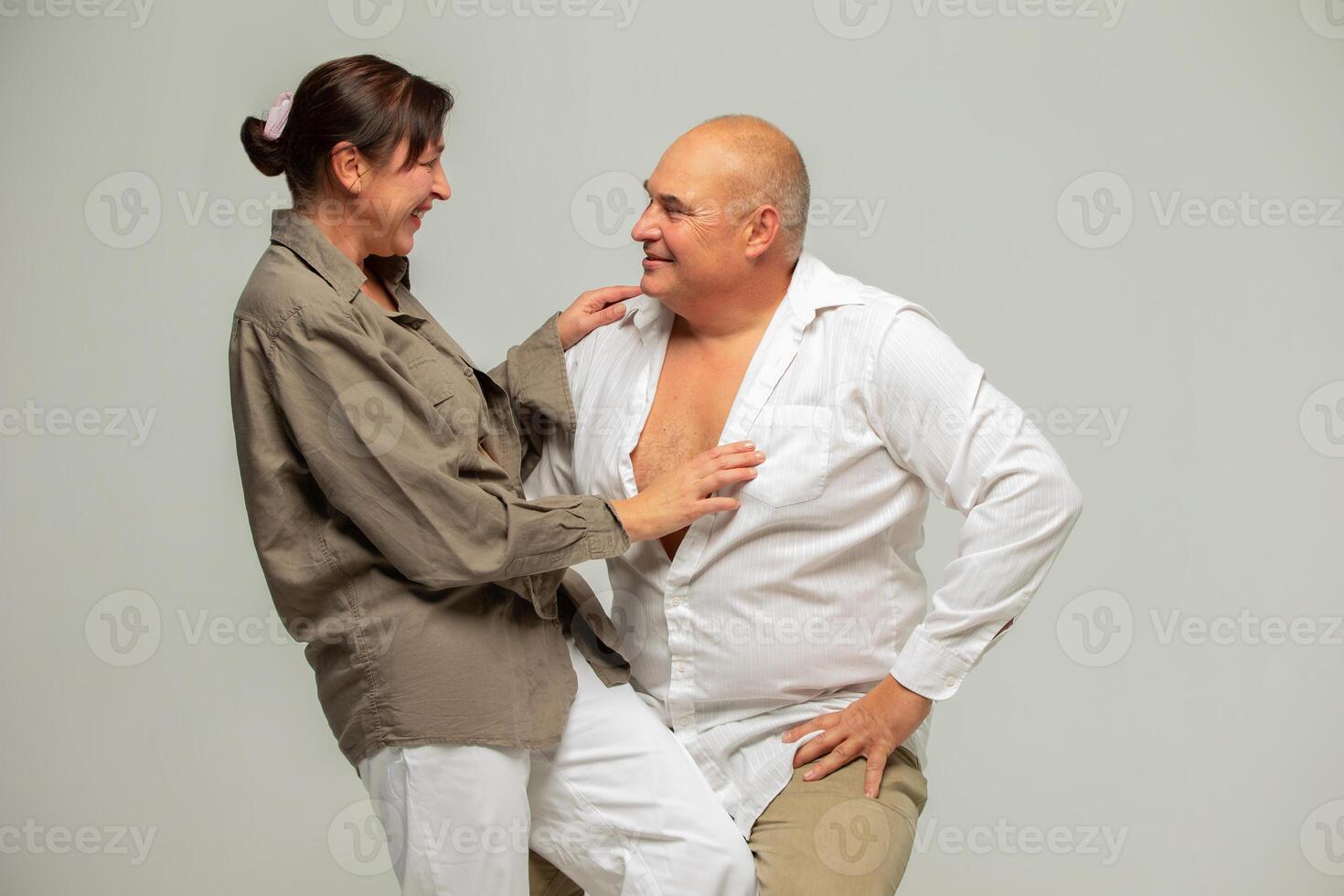 Portrait of a mature couple. Cheerful laughing funny couple, two friends, elderly gray-haired brunette man in casual clothes standing photo