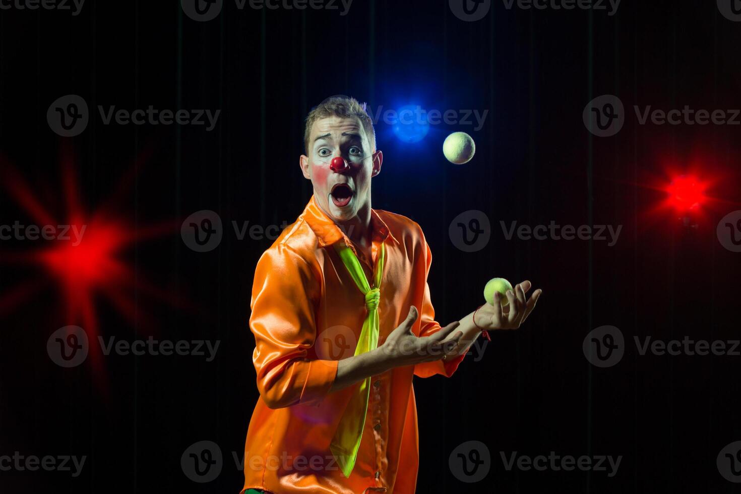 Circus clown performs number. Clown man juggles photo