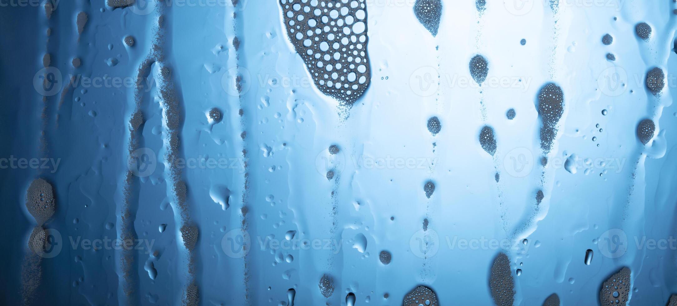 Water drops with foam on glass on a blue background. photo