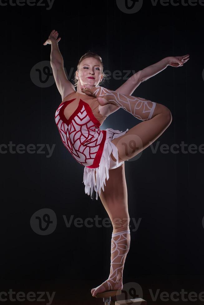 Circus actress performs the number in a beautiful smoke. Manual equilibrium on canes. Flexible girl body.Performance of an air gymnast in a circus photo