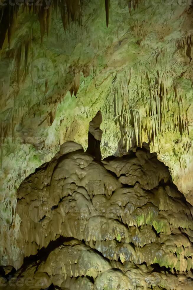 The cave is karst, amazing view of stalactites and stalagnites illuminated by bright light, a beautiful natural attraction in a tourist place. photo