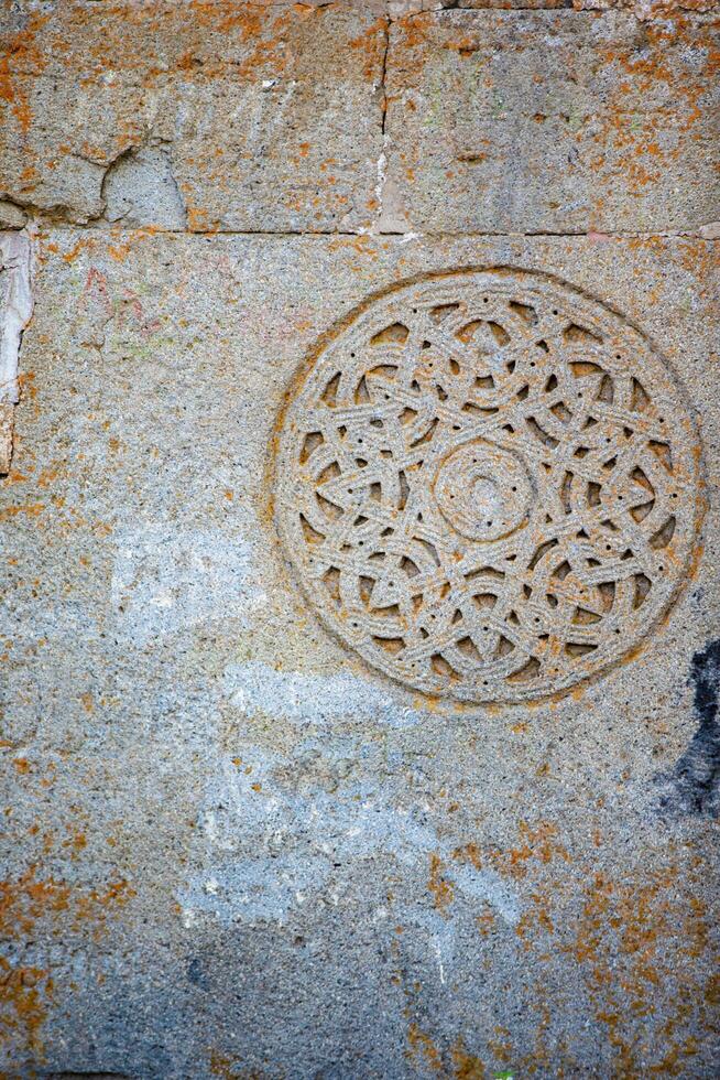 Clásico antiguo modelo decoración en el pared de un Roca georgiano iglesia. foto