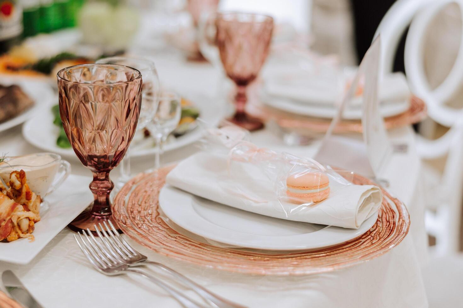 A view of wedding tables, attention to serving, with flower arrangements, expensive cutlery, plates with white napkins. photo