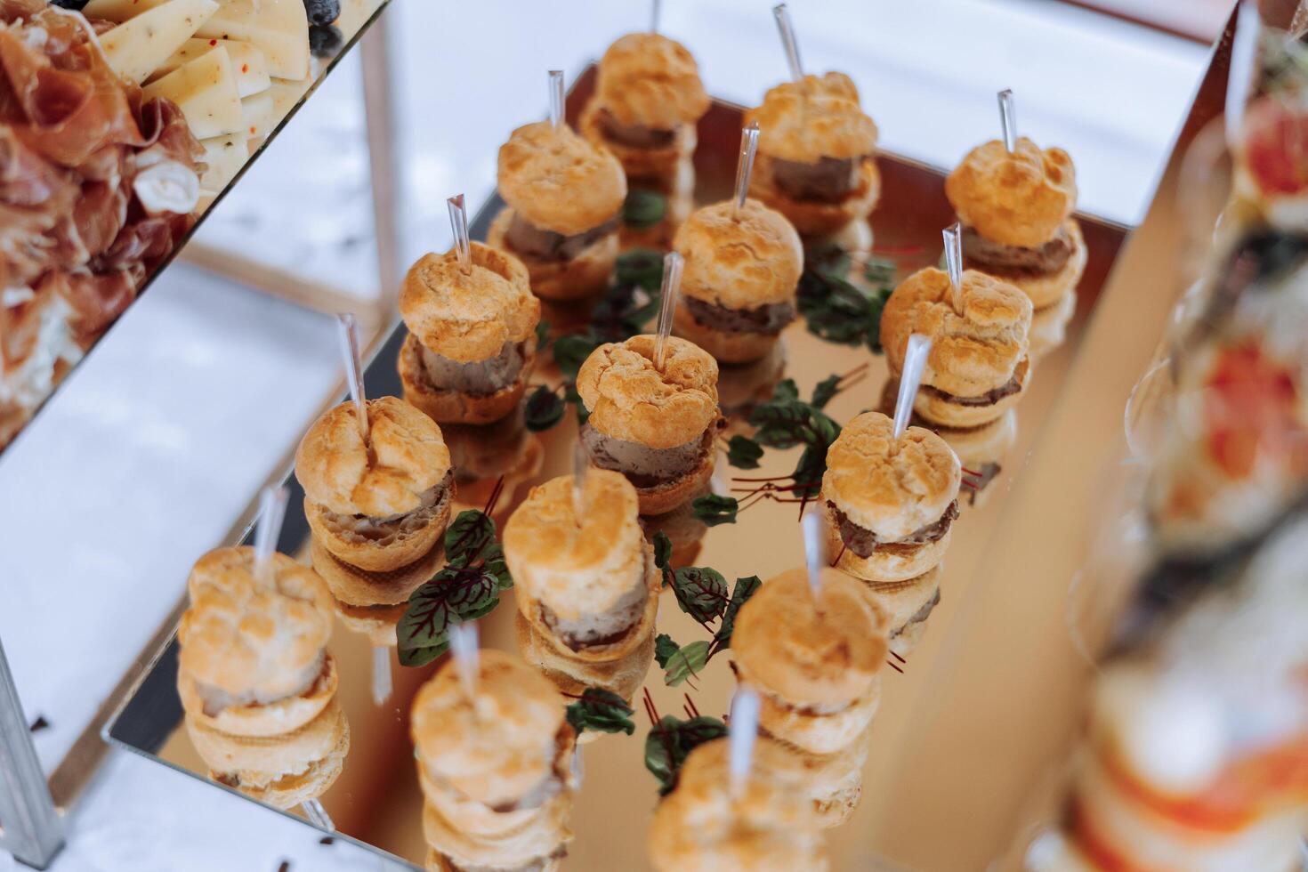 meat and cheese snacks on the buffet table. open-air buffet table, sandwiches on skewers before the start of the holiday. photo