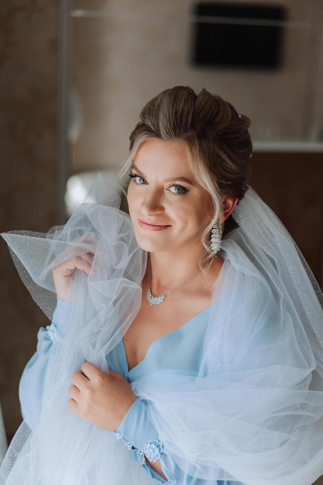 Beautiful bride in a dressing gown in the morning before the wedding ceremony. Incredible hairstyle of the bride. Natural and modern makeup. Portrait of a young bride in a dressing gown. photo