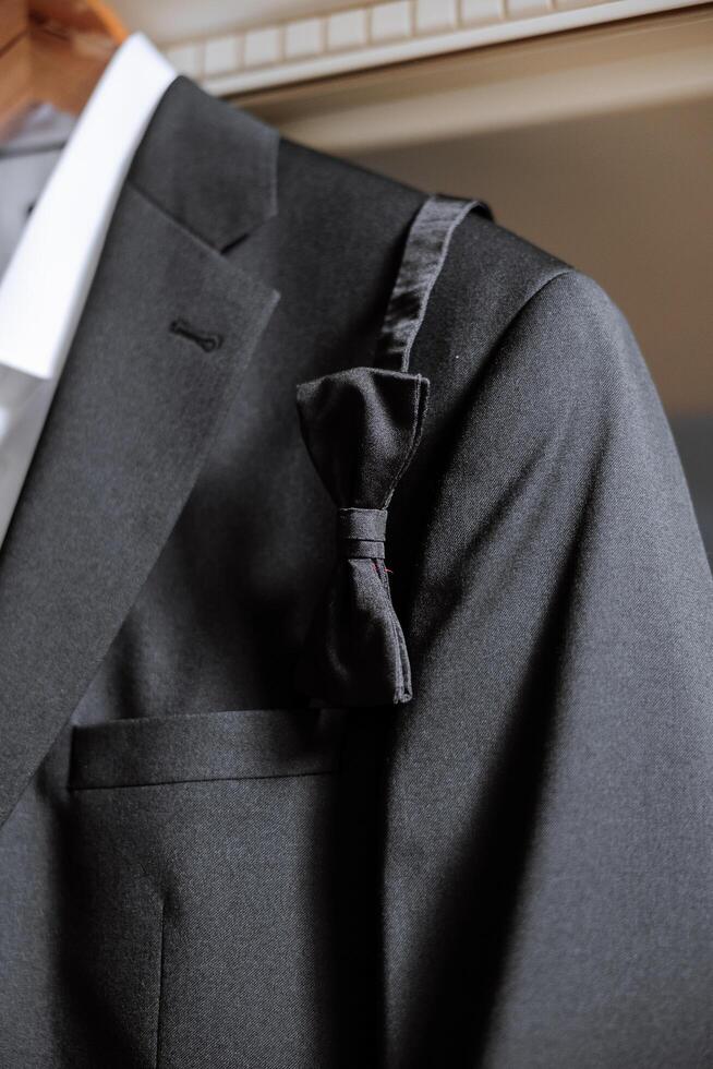 de los hombres negro arco Corbata en percha. accesorio para un formal recepción. un símbolo de elegancia y Moda para hombres. de los hombres casual. foto