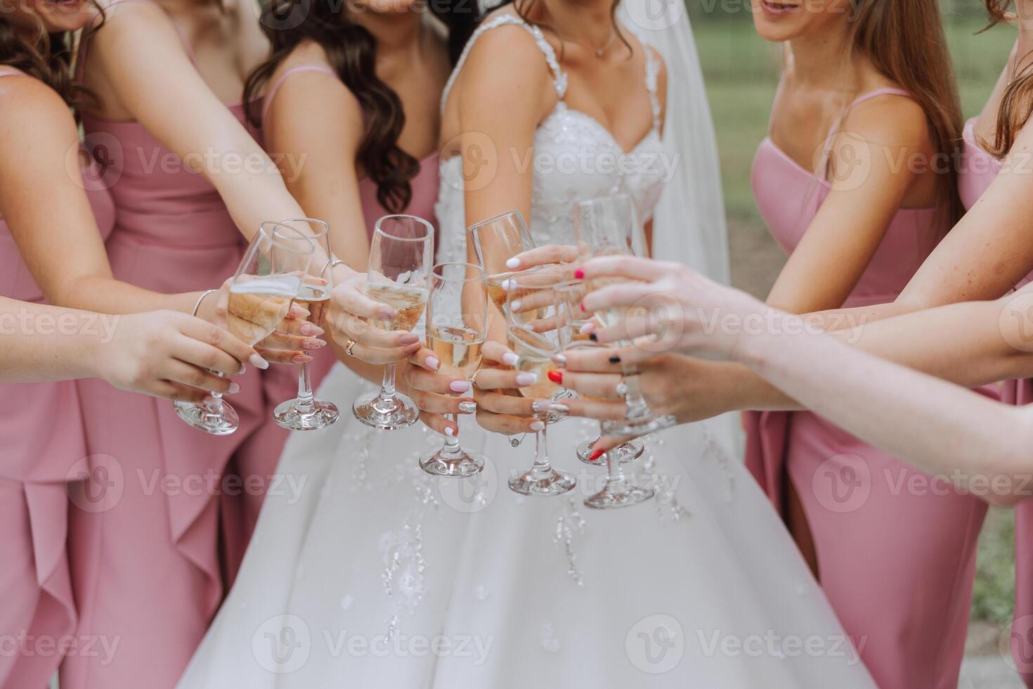 Photo bride with her friends drinking champagne from glasses. Cropped shot of a beautiful young bride and her bridesmaids having champagne before the wedding.
