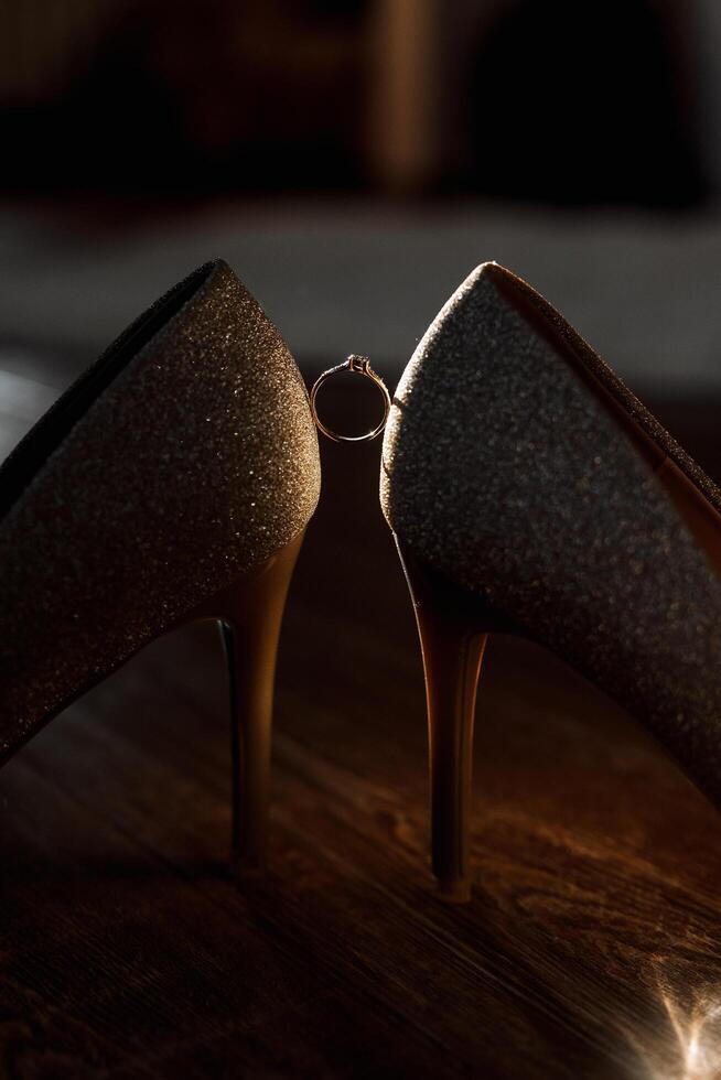 Bride's shoes. The girl wears stilettos. Elegant women's shoes. Beautiful details. The bride puts on her shoes and prepares for the wedding ceremony photo