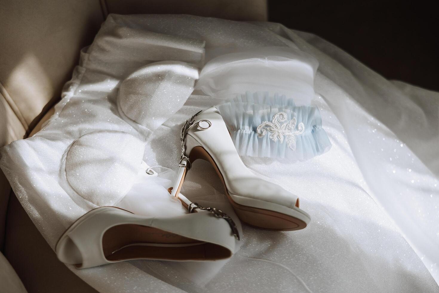 Bride's engagement ring, stilettos, Perfume. Wedding details of the bride. Flowers Beautiful light. wedding dress photo