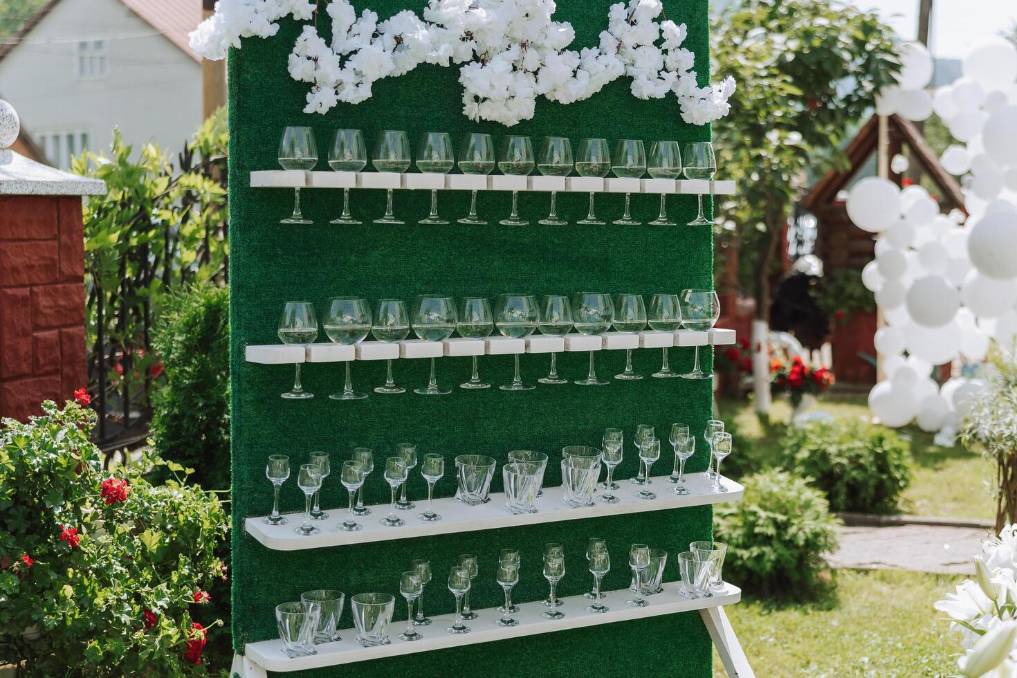 Green stand with champagne glasses. Many glasses for guests, preparation for the celebration. Details photo