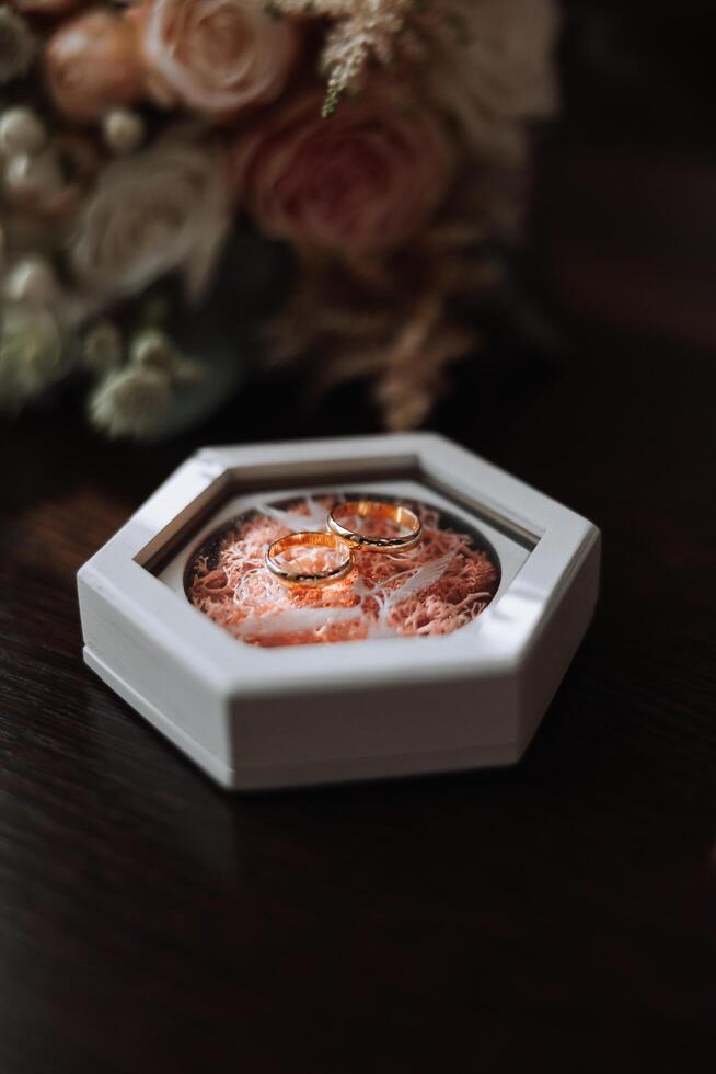 dos oro Boda anillos para novias como un símbolo de eternidad. todo es Listo para el Boda ceremonia. un oferta de un mano y un corazón foto