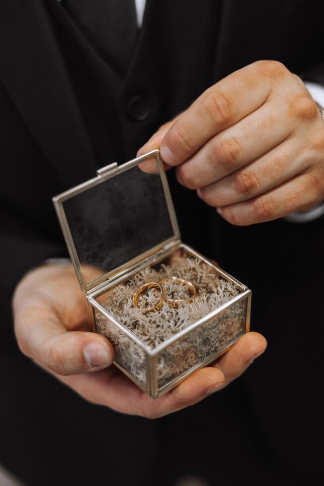 dos oro Boda anillos para novias como un símbolo de eternidad. todo es Listo para el Boda ceremonia. un oferta de un mano y un corazón foto